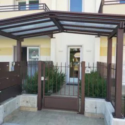 Cancello condominiale con recinzione e tettoia 